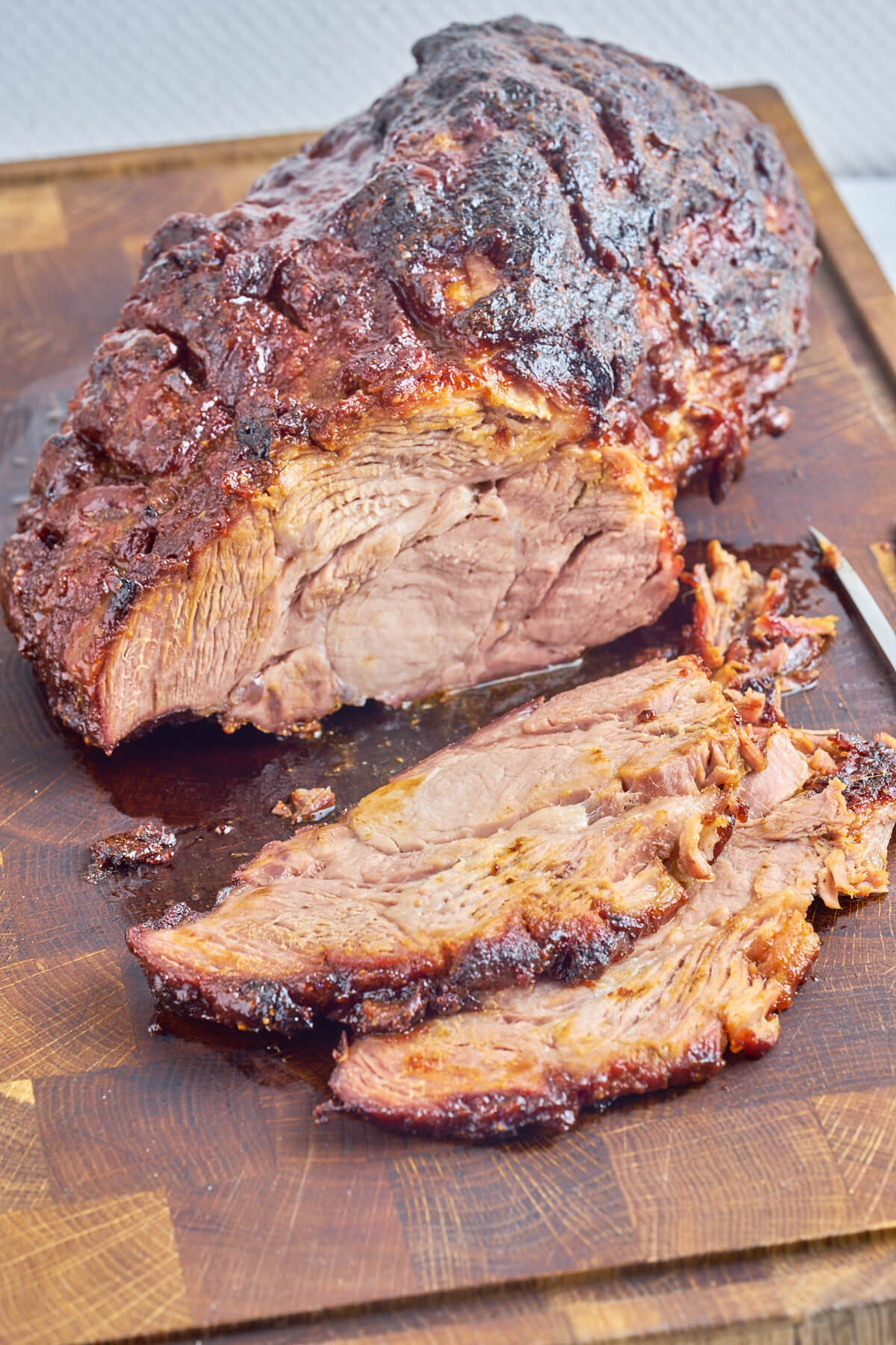 wooden board with sliced pork collar made on the grill