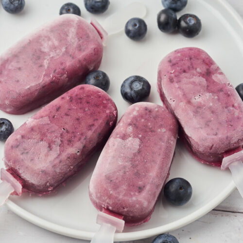 healthy blueberry popsicles with blueberries on a plate