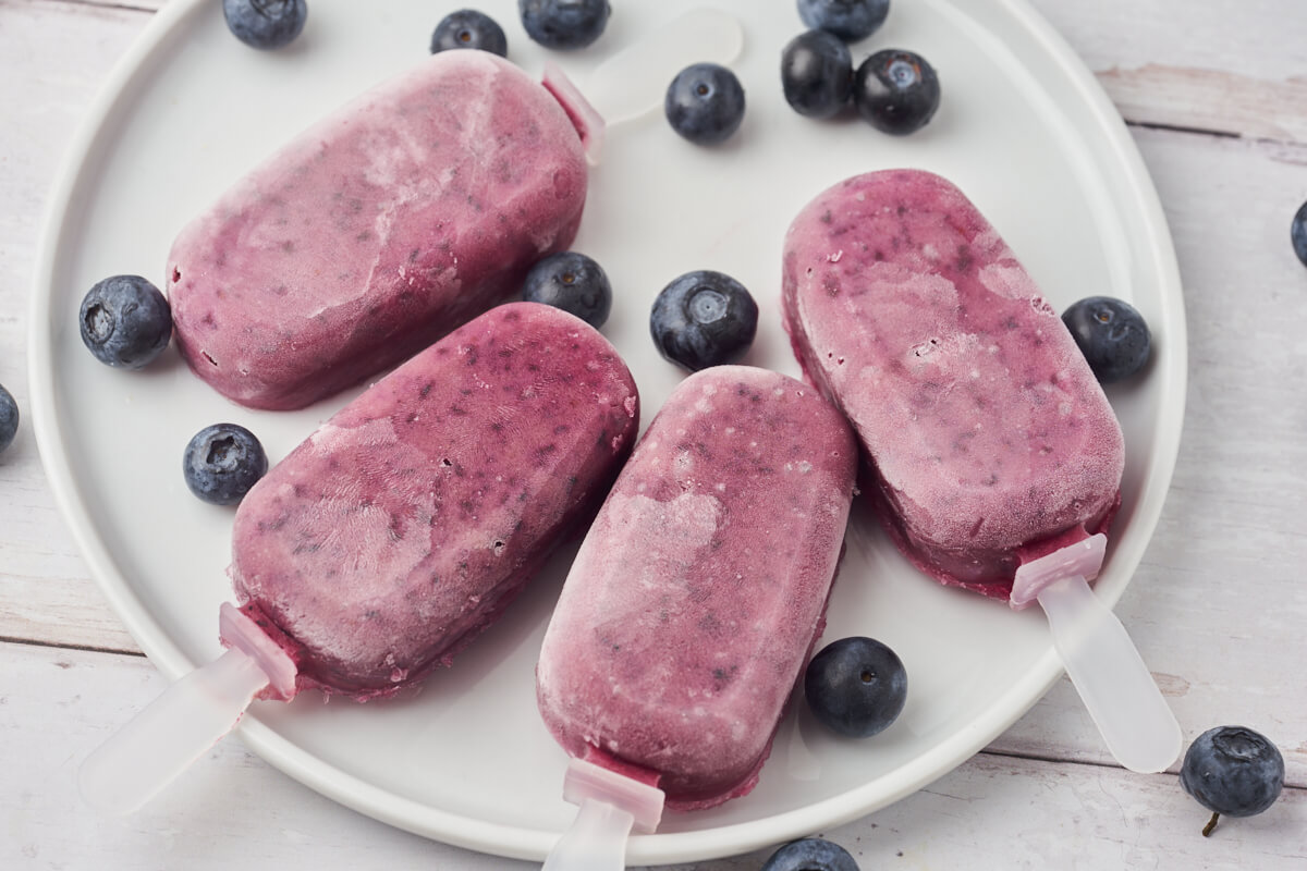 healthy blueberry popsicles with blueberries on a plate