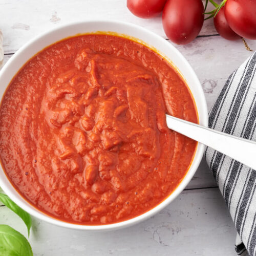 homemade pizza sauce with tomatoes, garlic and bazil in bowl