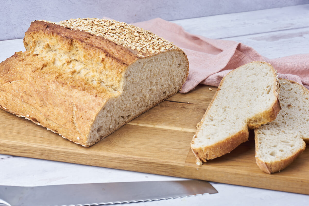 Homemade oat bread on a cutting board with slices of the bread