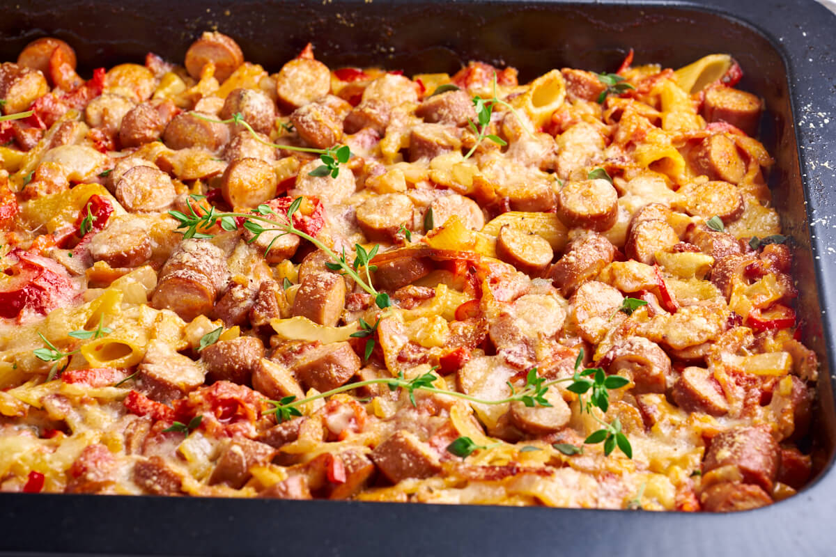 dish with bakes pasta with sausages and vegetables in a creamy tomato sauce