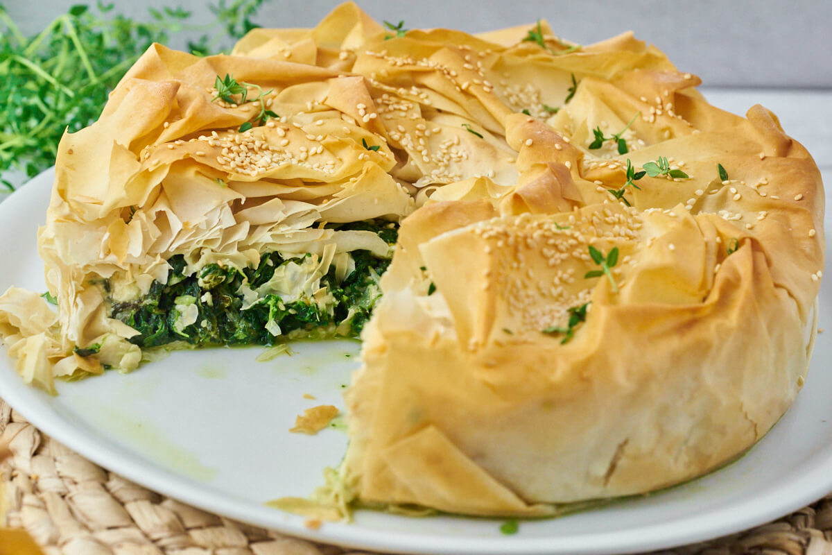 Greek spanakopita with spinach and feta inside, on a plate.