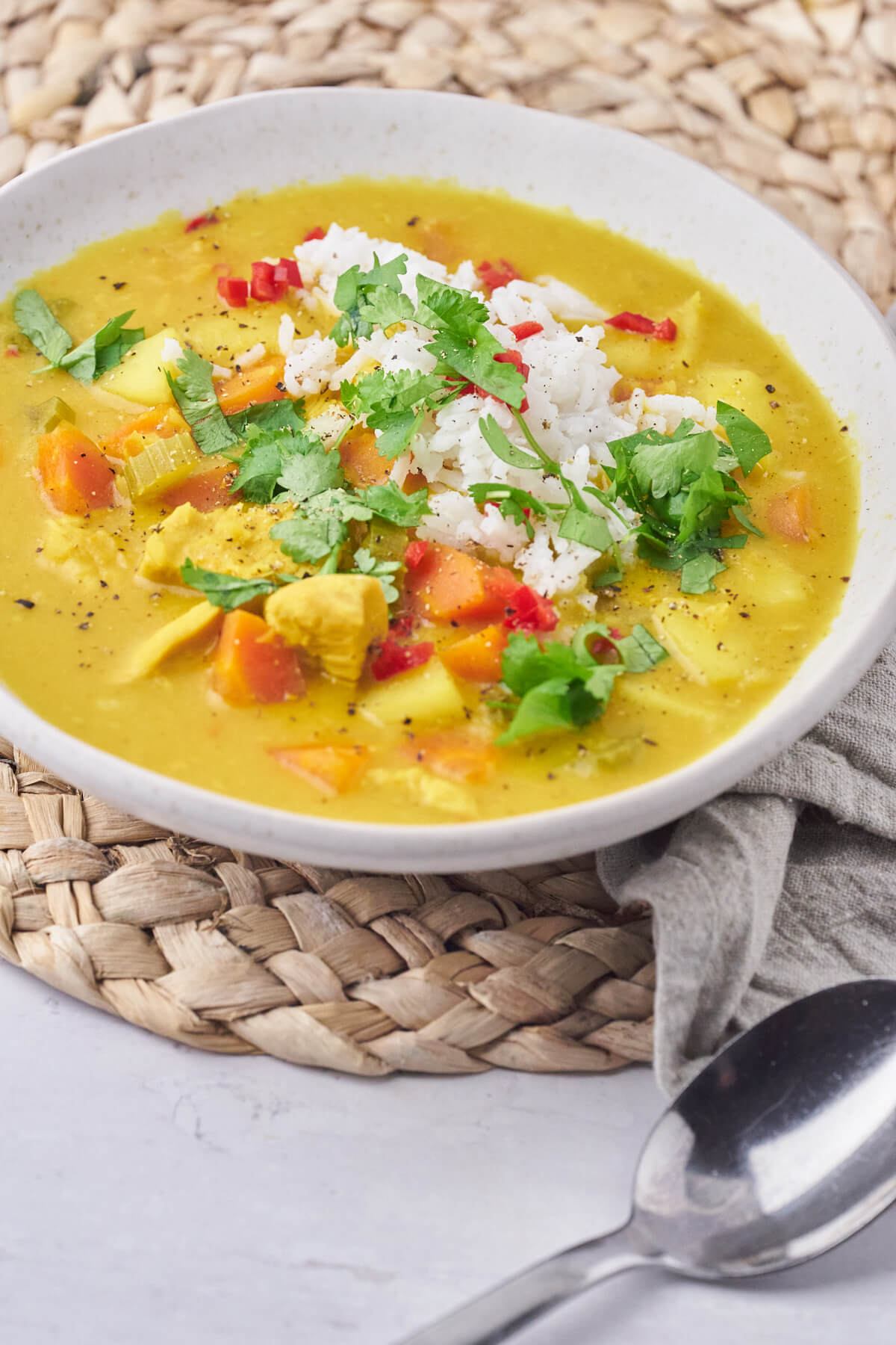 Indian mulligatawny soup with rice, chili and cilantro on top