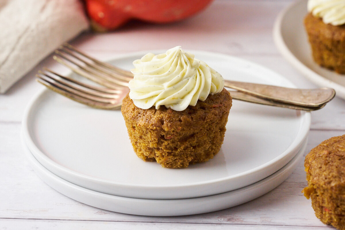 Plate with pumpkin muffin with cream cheese frosting