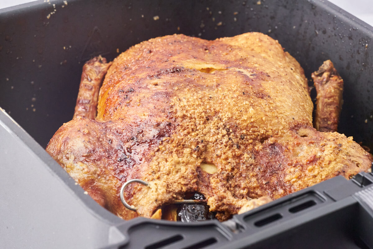 Duck roast filled with prunes and apples and secured with meat pins, then cooked in the air fryer.