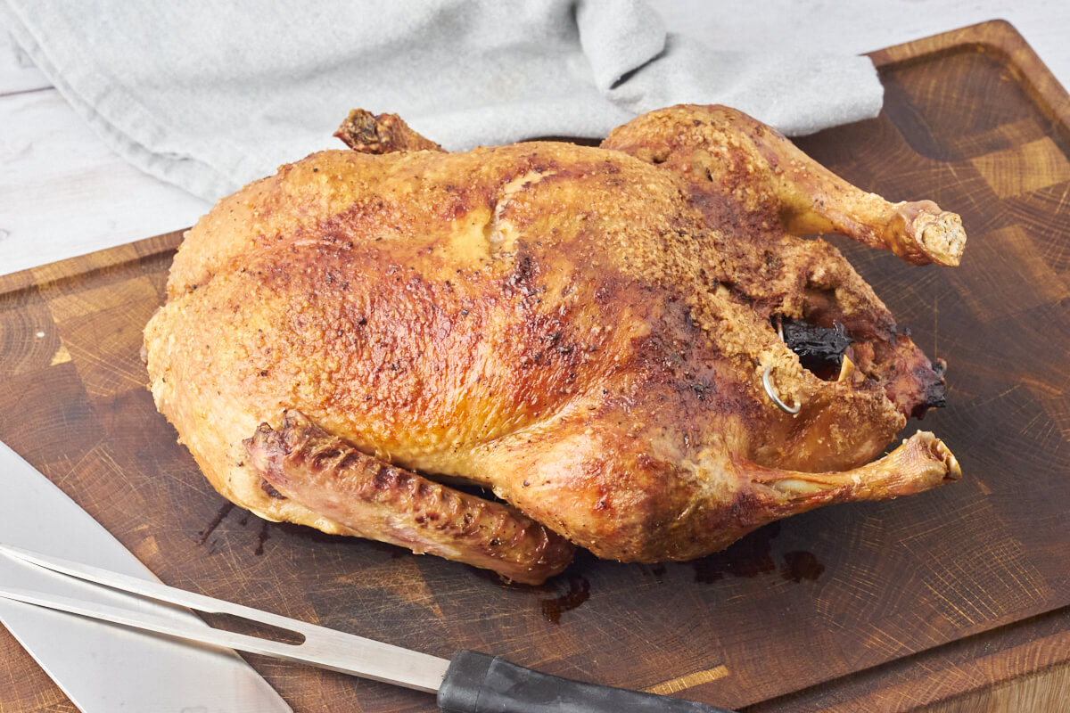 Whole Duck Roast resting on chopping board made in a Air Fryer.