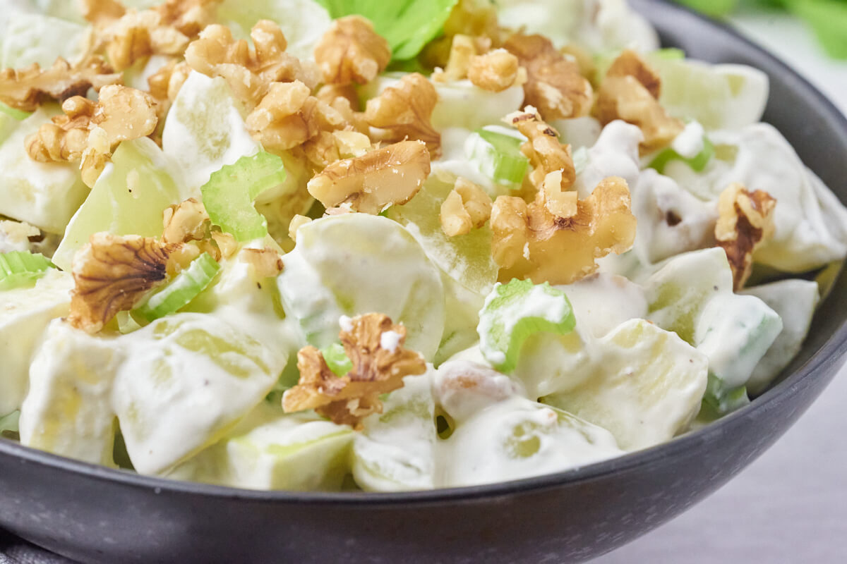 Salad with celery, grapes, walnuts, and apples in a creamy dressing made of whipped cream and sour cream.